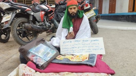 শরীরে কাফনের কাপড় জড়িয়ে বিষের বোতল নিয়ে সাংবাদিকের অবস্থান
